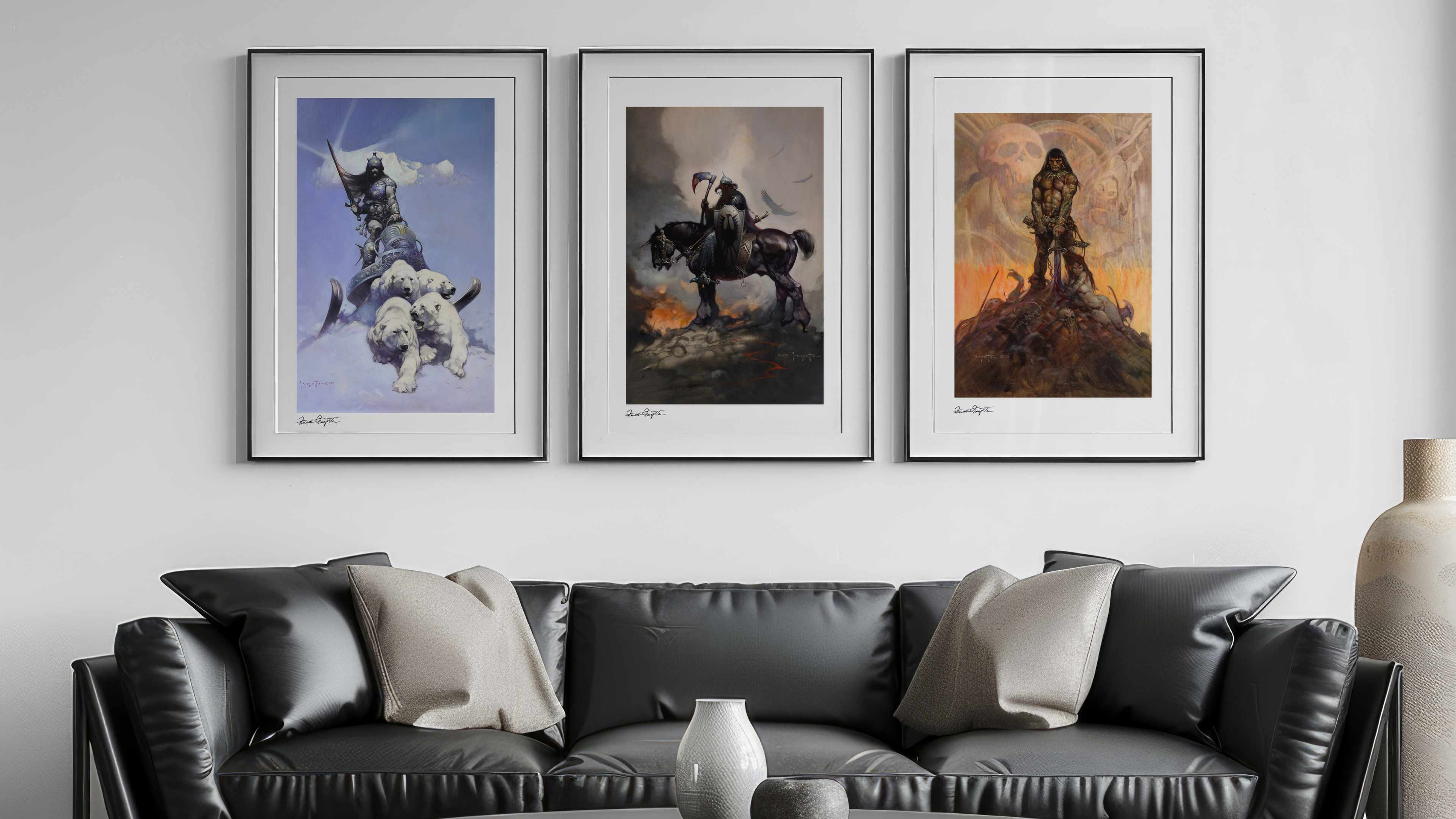 Framed Frazetta art prints displayed above a modern black leather couch. The artwork includes Silver Warrior, Death Dealer, and the Barbarian, each signed and elegantly framed in a minimalist setting